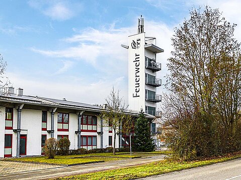 Bild zeigt die Wache der Feuerwehr Senden mit einem Turm mit dem, frisch aufgemalten Schriftzug "Feuerwehr Senden".